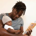 Man reading book with baby